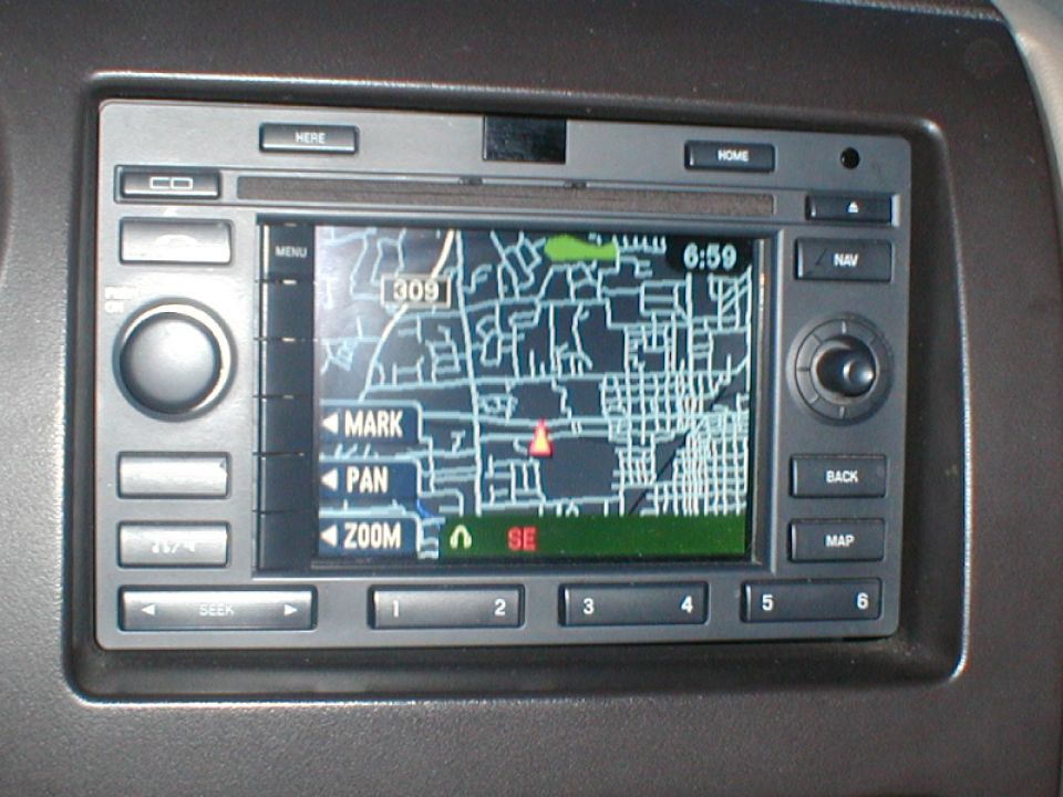 Car navigation screen displaying a map with street names and a red marker