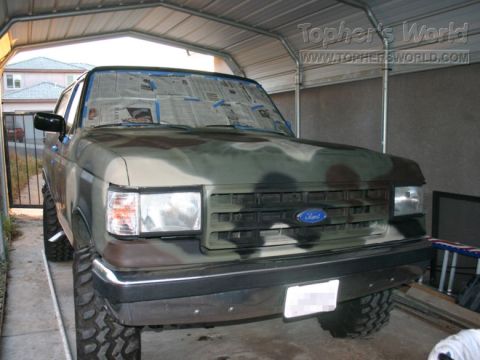 1978 Ford Bronco - Camouflaged Ford Bronco parked in a carport, ready for paint touch-ups.