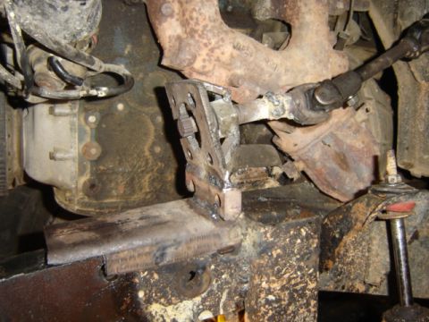 1989 Ford Bronco - Close-up view of a modified steering linkage and exhaust manifold, suggesting custom work on the vehicle's engine components.