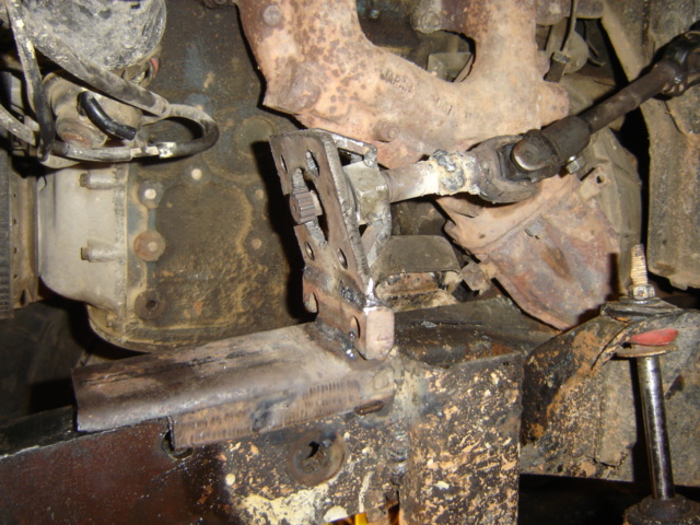 Modified steering linkage and exhaust manifold on a vehicle