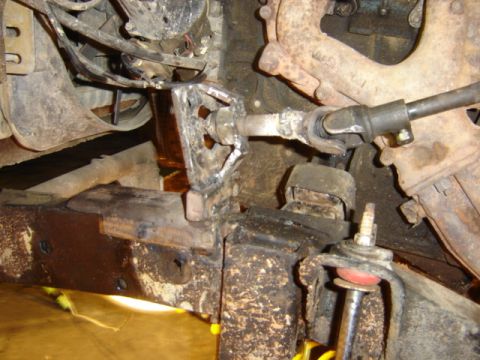 1989 Ford Bronco - Close-up view of modified steering and suspension components on a vehicle's undercarriage.