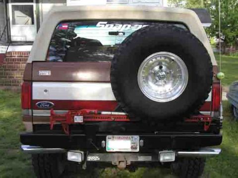 1988 Ford Bronco - Rear view of a 1988 Ford Bronco, showing the spare tire and a Hi-Lift jack mounted on the bumper.