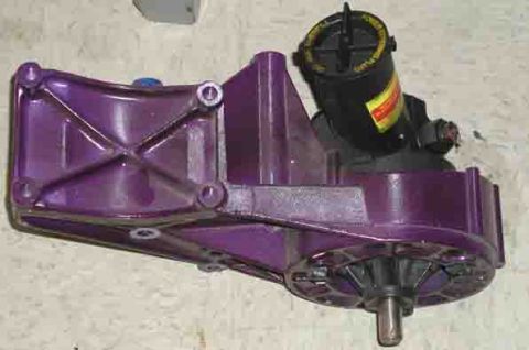 1988 Ford Bronco - A close-up view of a purple painted automotive part, possibly a power steering pump or similar component.