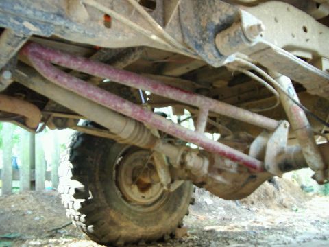 1985 Ford Bronco - The underside of a vehicle shows suspension components and a tire, with a watermark for Supermotors.net.