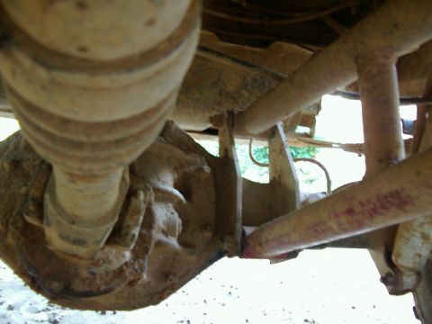 1985 Ford Bronco - Underside view of a vehicle's rear axle and suspension system components.
