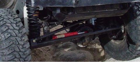 1999 Jeep Grand Cherokee - Close-up view of a vehicle's off-road suspension system and aggressive tire tread.