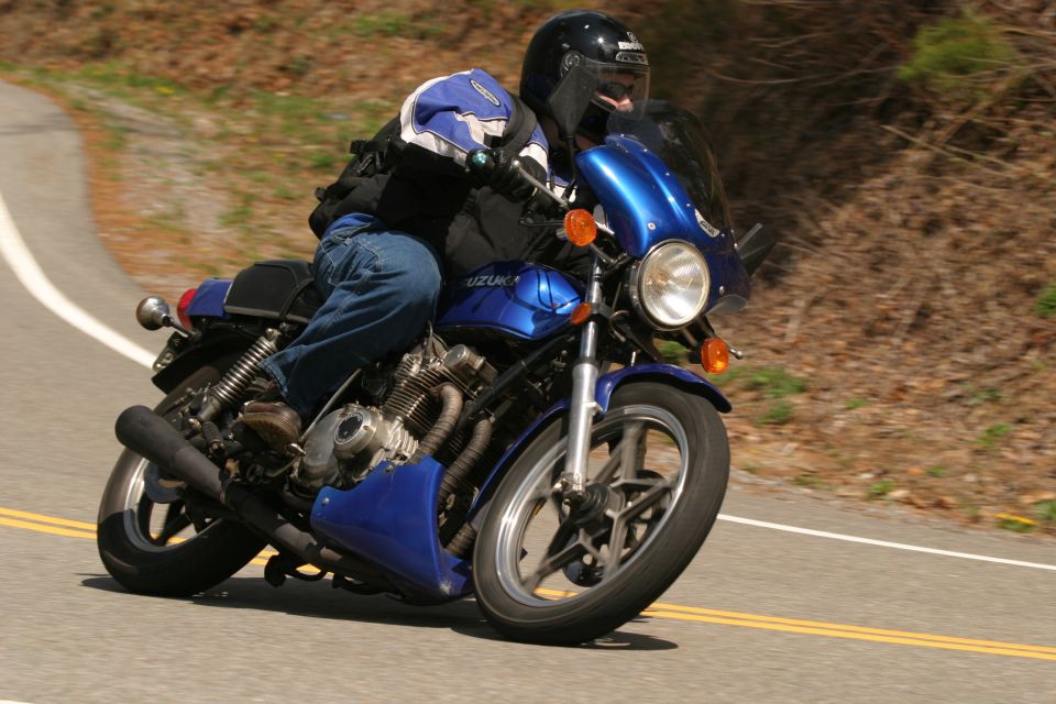 Blue motorcycle with a rider on a winding road