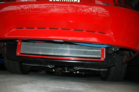 2000 Ford Mustang - Rear view of a red Ford Mustang showing an aftermarket differential cooler installed beneath the bumper.