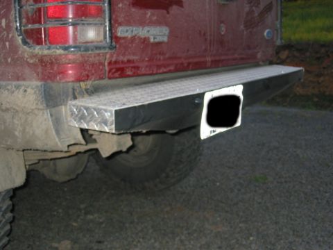 1991 Ford Explorer - Rear view of a red 1991 Ford Explorer with a diamond plate bumper and visible taillight.