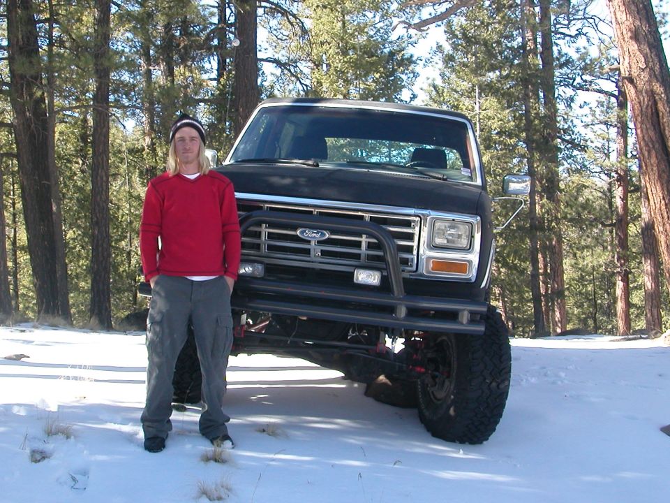 Black 1980s Ford Bronco with custom bumper and lift kit, front view