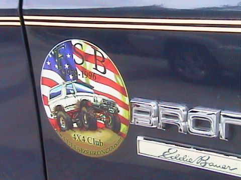 1991 Ford Bronco - Vehicle emblem and sticker detail on a dark blue car.