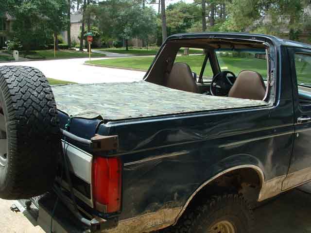 1993 Ford Bronco rear view with spare tire and camouflage soft top