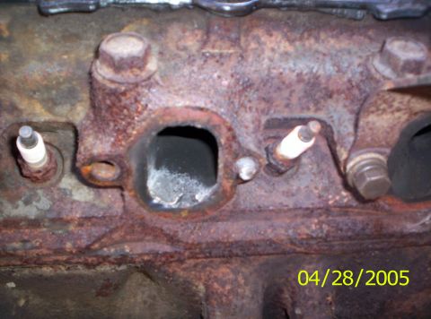 1985 Ford Bronco - This close-up shows a heavily rusted engine block with two spark plugs installed.