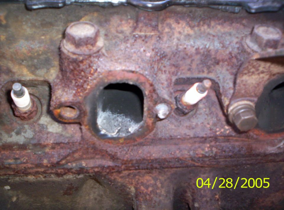 close-up of a rusty engine block with two spark plugs visible