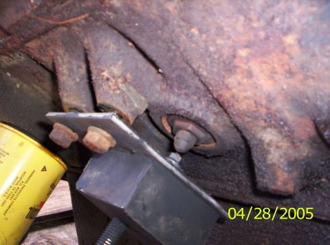 1985 Ford Bronco - A close-up view shows a rusty engine part, a yellow oil filter, and a black engine mount, dated 04/28/2005.