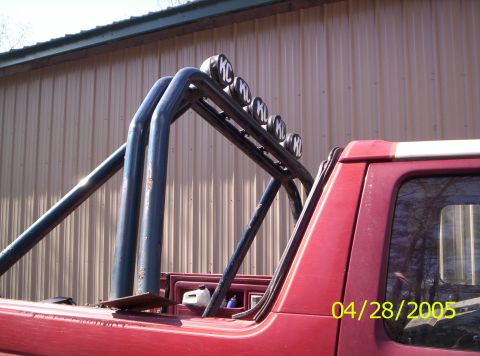 1985 Ford Bronco - Roll bar with KC lights on a red truck bed, dated 04/28/2005.