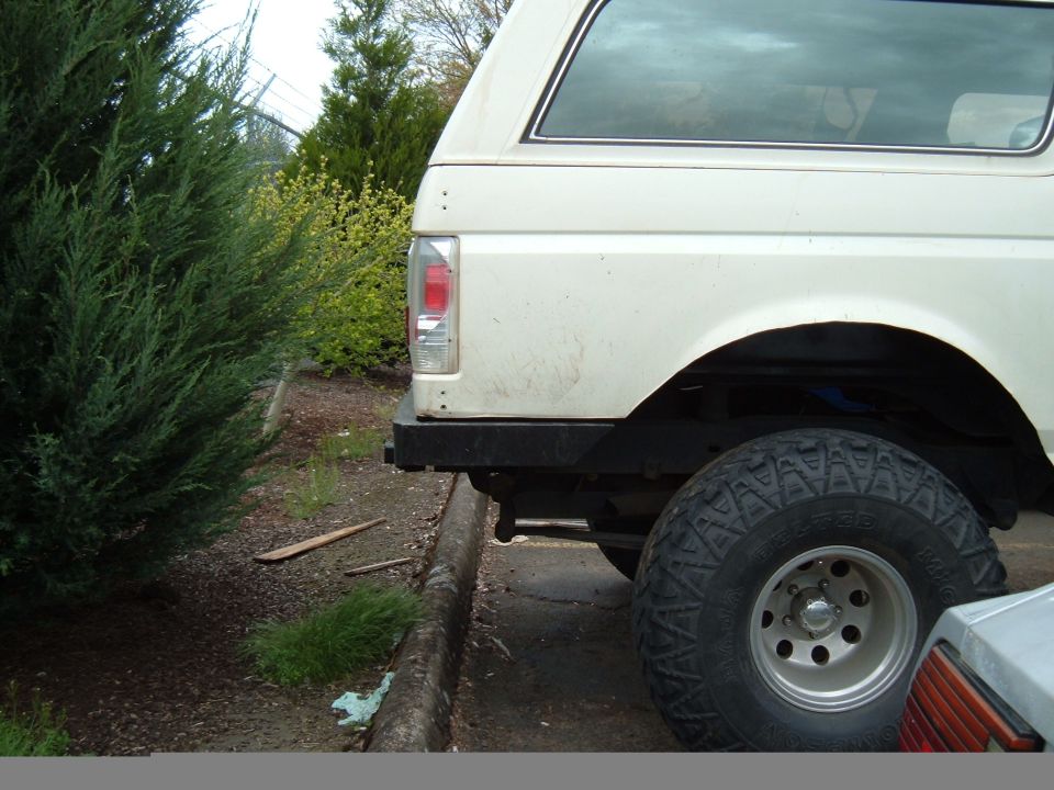 White Ford Bronco rear quarter with black steel bumper and Toyo mud-terrain tire
