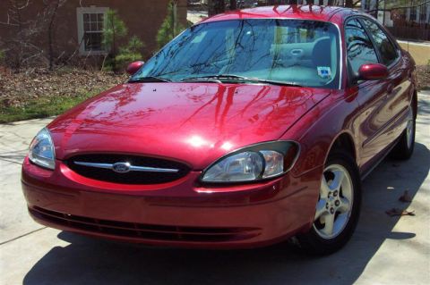2001 Ford Taurus - This red sedan, likely from the early 2000s, is shown from the front three-quarter angle.