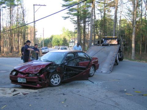 1991 Ford LTD Crown Victoria - A severely damaged sedan is loaded onto a tow truck after an accident, with emergency personnel on scene.