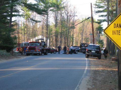 1991 Ford LTD Crown Victoria - Multiple tow trucks and emergency personnel are present at a roadside incident involving a red car.