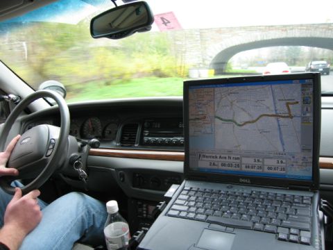 1991 Ford LTD Crown Victoria - Police car interior with GPS navigation system active on the laptop screen.