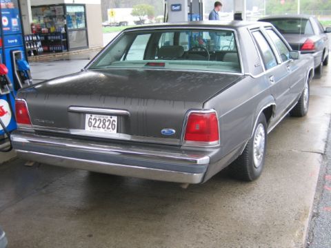 1991 Ford LTD Crown Victoria - Rear view of a 1991 Ford Crown Victoria LTD at a gas station, with another vehicle behind it.