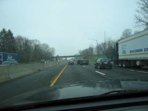 1991 Ford LTD Crown Victoria - A view from a car driving on a highway with various vehicles on a cloudy day.