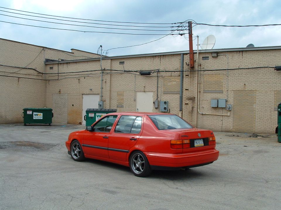 1994 Volkswagen Jetta sedan, red, parked in an alley with dumpsters