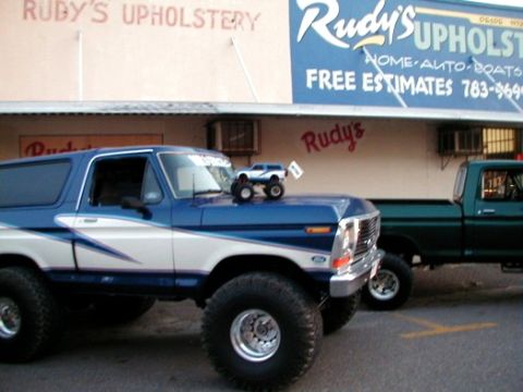 1979 Ford Bronco - A lifted 1979 Ford Bronco is parked in front of Ruby's Upholstery, with a toy Bronco on its hood.