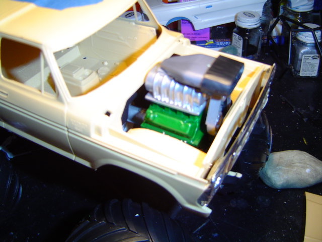 Model of a cream-colored vehicle with a supercharged engine in the engine bay