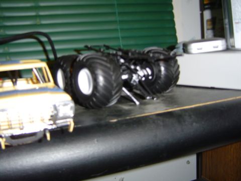 1979 Ford Bronco - A toy monster truck with oversized tires is shown next to a partial view of another toy truck.
