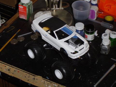 1979 Ford Bronco - Model monster truck kit with large tires and exposed engine detail on a workbench.