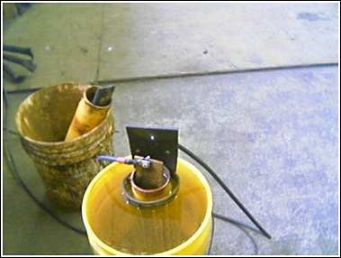 1993 Ford Bronco - Two buckets and some plumbing parts are shown in a workshop setting.