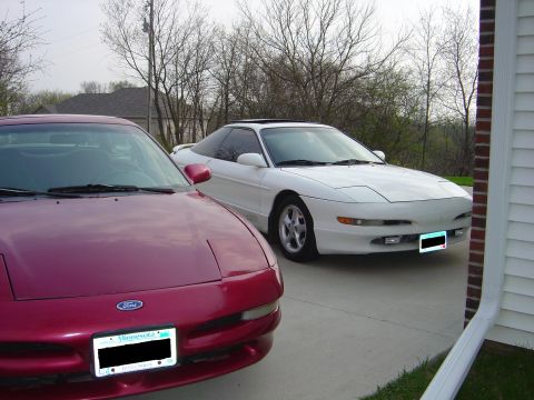 1993 Ford Probe - Two Ford Probes, one white and one red, are parked in a driveway.