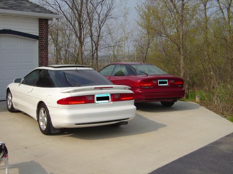 1993 Ford Probe - Two Ford Probes, one white and one red, are parked side-by-side in a driveway.