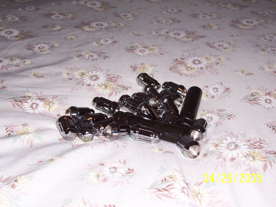 Pile of chrome lug nuts on a floral patterned surface. Date stamp reads 04/29/2005