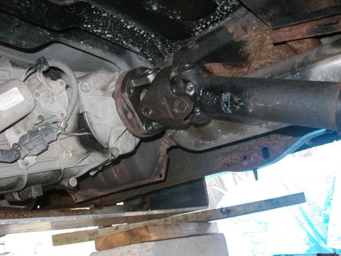 1994 Ford Bronco - Underside view of a vehicle's driveshaft and transmission, showing signs of rust on the frame.
