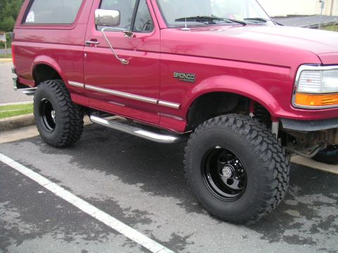 1994 Ford Bronco - This red 1994 Ford Bronco is equipped with off-road tires and side steps.