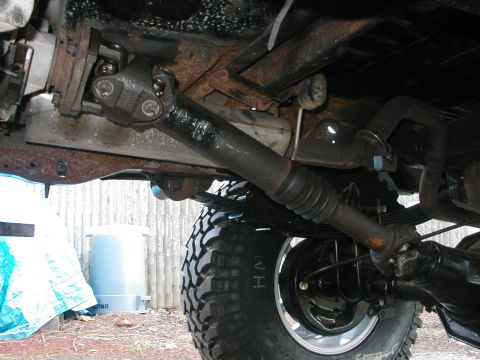 1994 Ford Bronco - Close-up of the driveshaft and rear axle assembly of a vehicle, showing mechanical components.