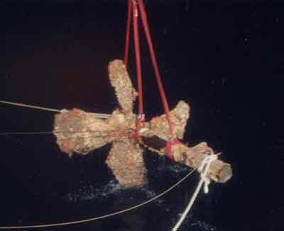 1988 Ford Bronco - A corroded boat propeller is hoisted from the water, showing signs of wear and tear.