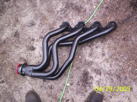 1985 Ford Bronco - A set of black exhaust headers lies on the ground, with a date stamp visible in the corner.