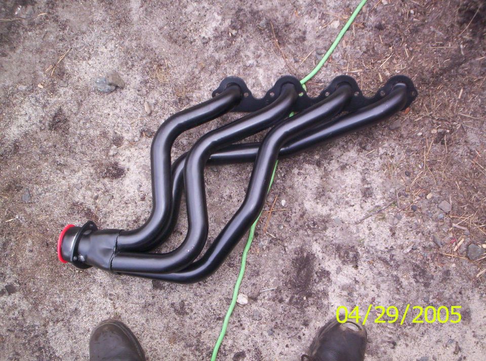 Black exhaust headers on the ground. Date stamp says 04/29/2005