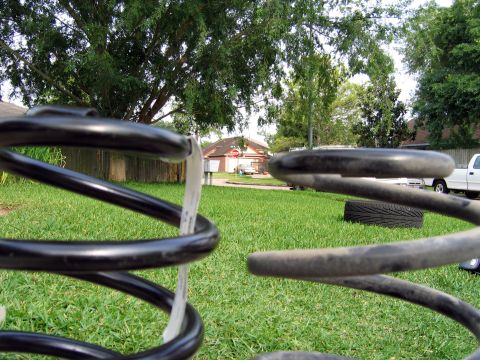 2000 Ford Crown Victoria - Close-up of suspension springs with a white pickup truck visible in the background.