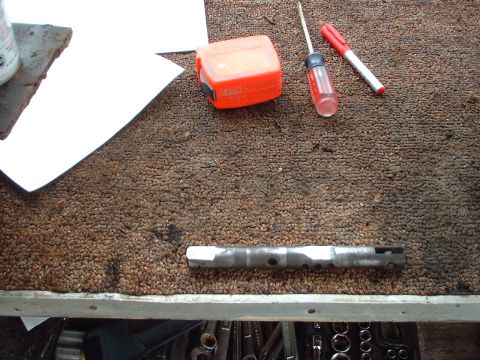 1976 Ford F-150 - Tools and a metal component are laid out on a textured surface, possibly a workbench.