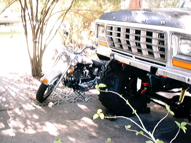 1979 Ford Bronco grille and motorcycle parked on patterned concrete