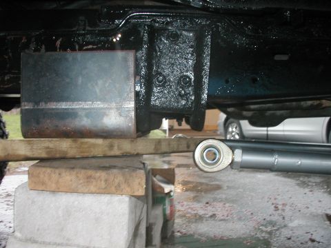 1994 Ford Bronco - A metal plate is being welded onto the vehicle's frame, which is supported by blocks and wood.