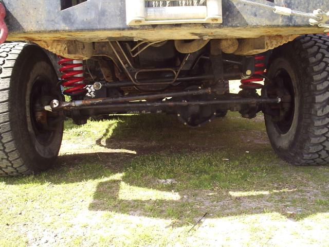 Front underside of lifted Bronco with solid axle and red coil springs