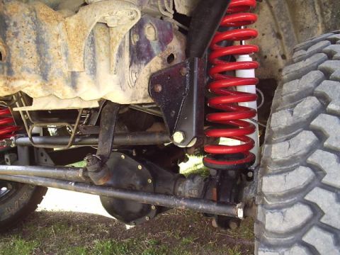 1994 Ford Bronco - Close-up view of a vehicle's off-road suspension system, highlighting the coil spring and shock absorber.