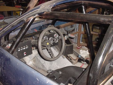 1984 Chevrolet Camaro - Custom interior of a race car, a roll cage and racing steering wheel. Year is not discernible.