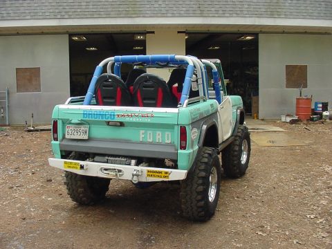1969 Ford Bronco - This modified Ford Bronco features a roll cage and oversized tires, with "Bronco Driver Magazine" text visible on the tailgate.